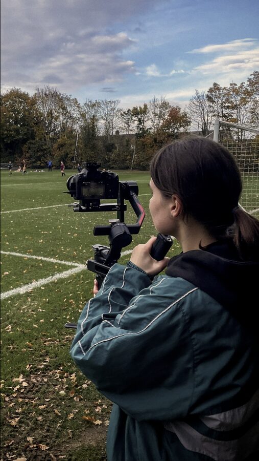 Ana filming a football match on a gimbal