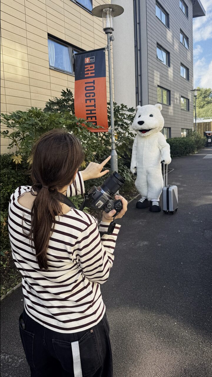 Anastasiia directing the university mascot by an RH Together banner